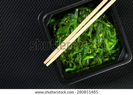 Japanese seaweed salad with bamboo chopsticks represent the Japanese food and cuisine concept related idea.