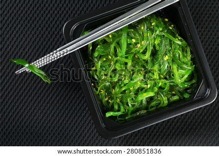 Japanese seaweed salad with shiny stainless chopsticks represent the Japanese food and cuisine concept related idea.