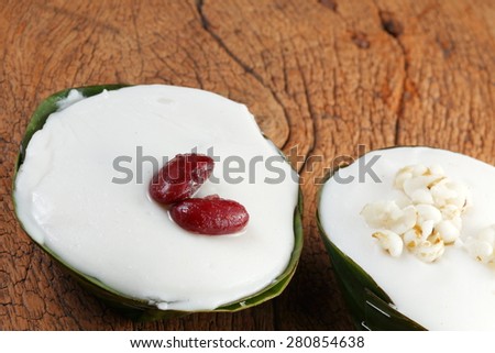 Thai pudding with coconut topping or in Thai name Ta Ko in banana leaf cup represent the Thailand traditional dessert and cuisine concept relate idea.