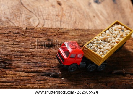 Plastic toy truck model red color with stone loaded represent the transportation concept related idea.