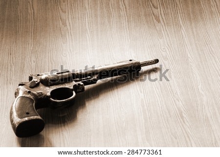The artificial vintage plastic toy gun beside artificial bullet shape toy on sepia tone represent crime science investigation instrument concept related idea