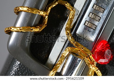 Old and dirty briefcase with gold necklace and plastic heart shape red color represent the business concept related idea.