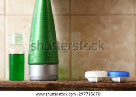 Contact lens container case unit put on toilet wood shelf represent the contact lens and healthcare concept related idea.