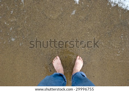 Naked male feet on wet sand