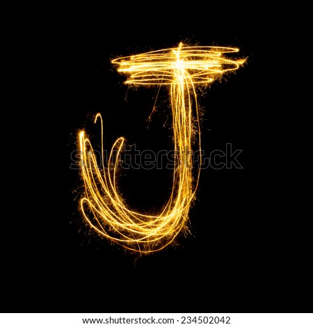 Sparkler firework light alphabet J with uppercase isolated on black background.