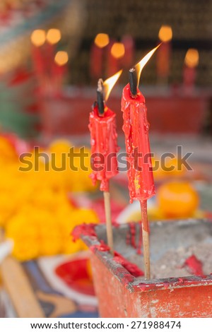 Burning red candle in pot at chinese shrine for making merit in chinese new year festival.