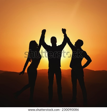 Group of people at sunset rejoices victory