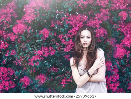 portrait of a beautiful brunette young woman in summer colors flowers hair-style xxl