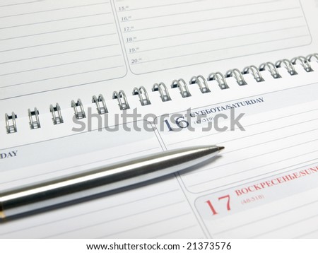 blank calendar with spiral binding and pen closeup. shallow dof