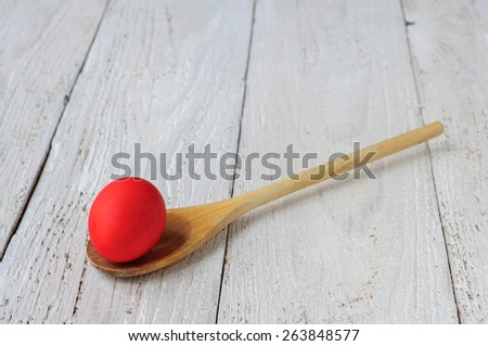 Colored easter eggs in spoon on wooden white shabby background