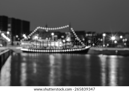 Blurred night city background with the boat on pier