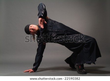 The man in a black raincoat on a grey background