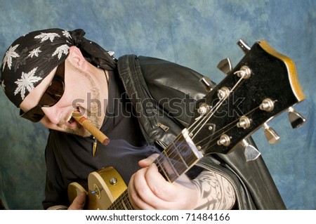 Rock guitarist is playing against the blue background