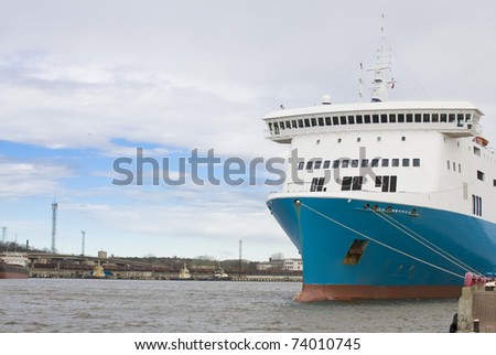 Ship at the pier against the background of the industrial landscape