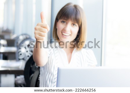 Business woman gives thumbs up for business success