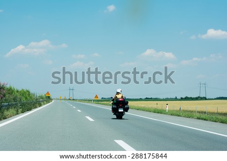 Motorcycle with two passengers on the high way in full speed.