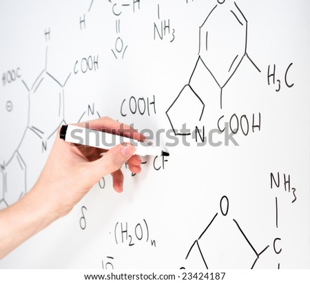 Someone writes a chemical formula on a whiteboard with a marker. It looks interesting and scientific.