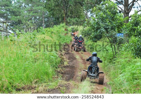 CHIANG MAI, THAILAND - NOVEMBER 23 : Tourists riding ATV to nature adventure on dirt track on NOVEMBER 23, 2013 in Chiang Mai, Thailand.