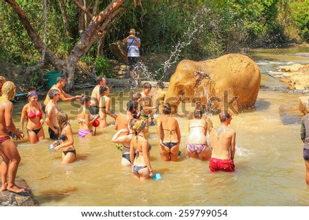 CHIANG MAI, THAILAND - MARCH 9 : People have opportunity to experience the lifestyle of elephants and wash elephant in river. (no hook, no chain, no riding) on MARCH 9, 2015 in Chiang Mai, Thailand.