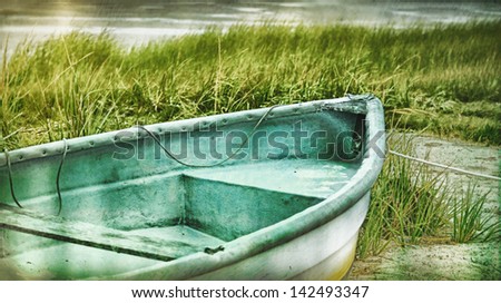 Old rowboat on the beach in the dune grasses, Bass River,  Cape Cod Massachusetts, USA. Vintage retro feel.