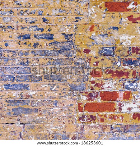 Grunge weathered chipped brick wall red blue yellow and white  peeling paint abstract background texture. Also bricks and mortar concept.