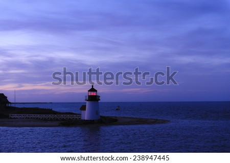 The Brant Point Lighthouse at the entrance to Nantucket Harbor at sunset. Beautiful travel scene at night. Brant Point Light House is the shortest lighthouse in New England.
