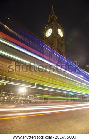 Night view on Big Ben and light trail of a bus in front.