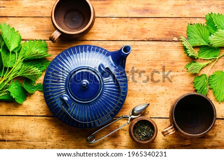 Herbal tea with nettle leaves on wooden background.Herbal medicine,homeopathy