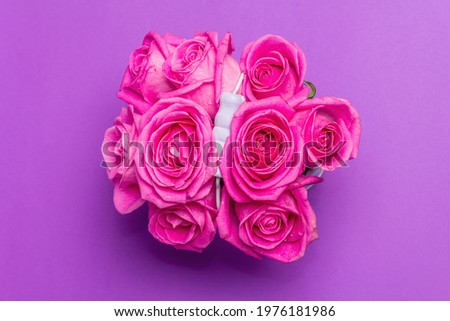 Bouquet of fresh pink roses in a bucket. The festive concept for Weddings, Birthdays, March 8th, Mother's, or Valentine's Day. Greeting card, lilac background