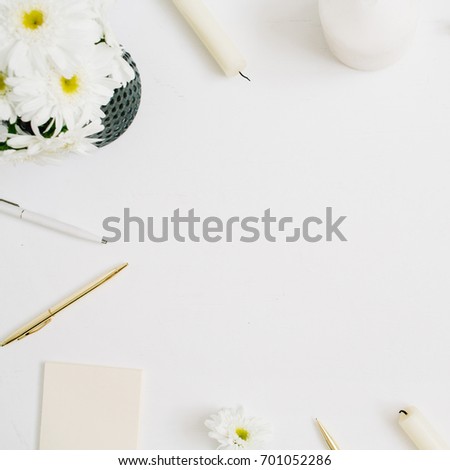 Flat lay home office desk with layout space for text. Woman workspace with chamomile flowers bouquet and marble diary on white background. Top view feminine background.
