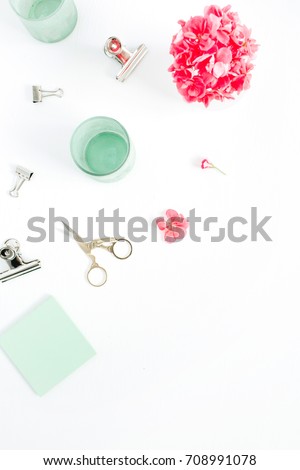 Flat lay fashion office desk. Female workspace with red flowers, accessories, mint diary on white background. Top view feminine background.