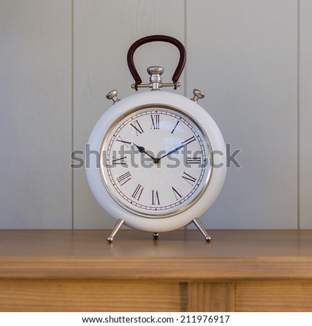 Big old vintage clock on wooden table