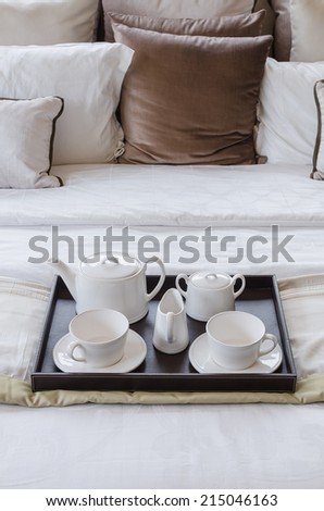 tray of white tea set on bed in bedroom