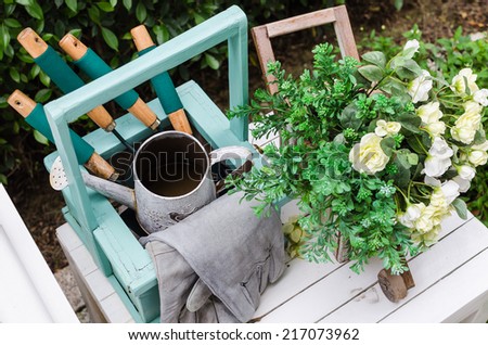 Gardening tools on wooden table in garden at home