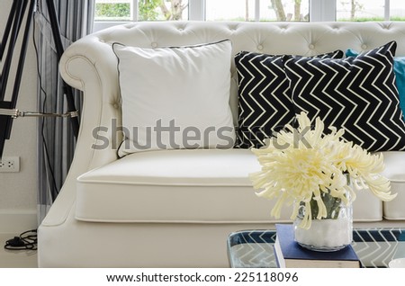luxury white sofa in living room with yellow flower in vase at home