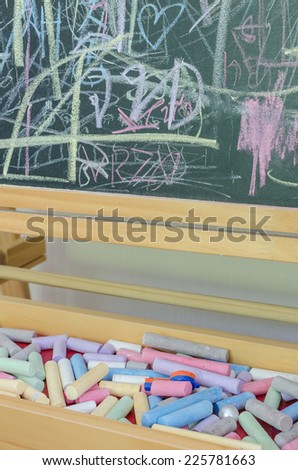 Multicoloured chalk and chalkboard at home