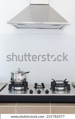 stainless pan on gas stove with hood in kitchen