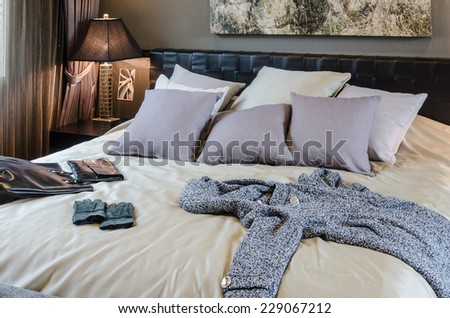 luxury bedroom with clothes and bag on bed