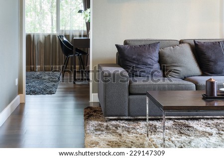 living room with black sofa and wooden table on carpet