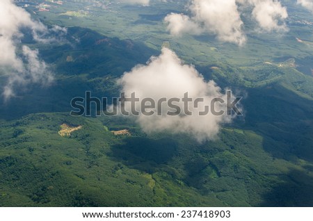 View of the land, fields, and clouds from above