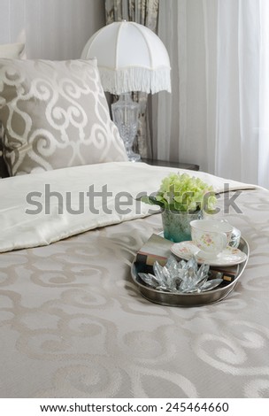 luxury bedroom with tea cup and plant in tray on bed at home