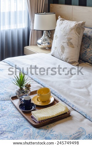 wood tray of tea cup and plant on bed at home