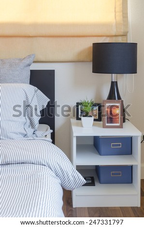 white table with plant in vase and black lamp in bedroom at home