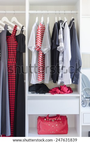 white closet with shirt and dress hanging at home