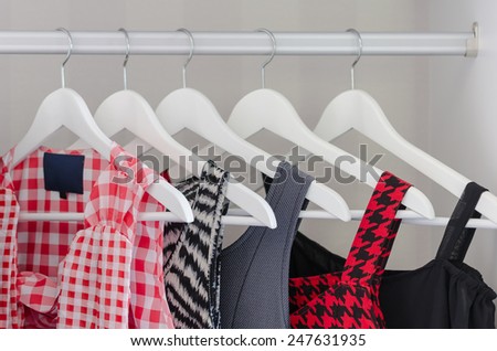 row of dress hanging on coat hanger in white wardrobe