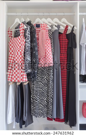 white closet with shirt and dress hanging at home