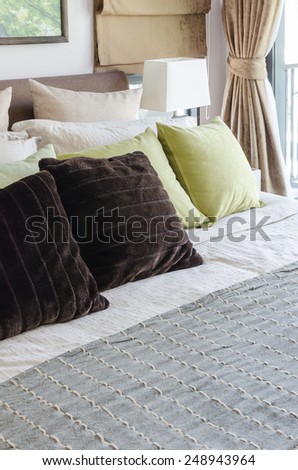 brown pillows and green pillows on bed in bedroom at home