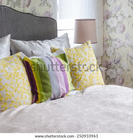 female\'s bedroom with colorful pillows on bed at home