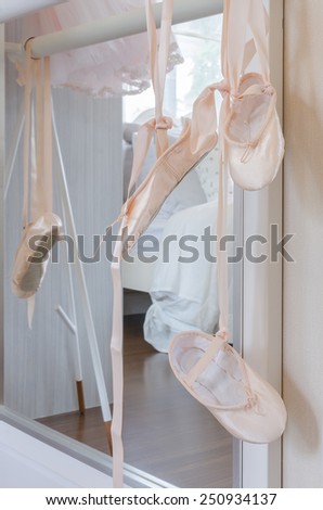 ballet shoes hang on bar in bedroom