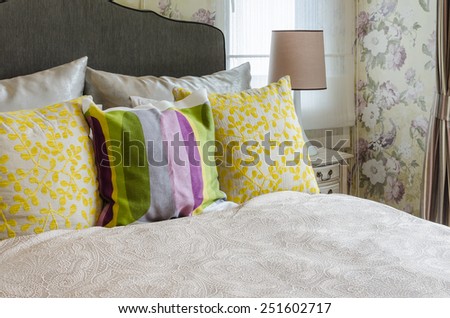 female\'s bedroom with colorful pillows on bed at home